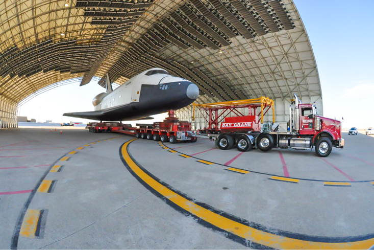 Truck carrying space shuttle out of hangar