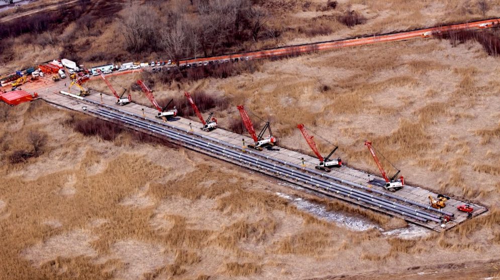 Multiple cranes simultaneously lifting heavy load