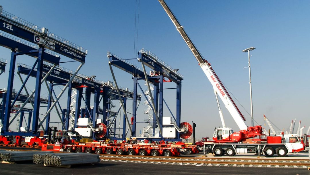 Truck cranes moving harbor cranes into place