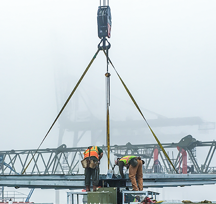 Workers and crane on foggy day