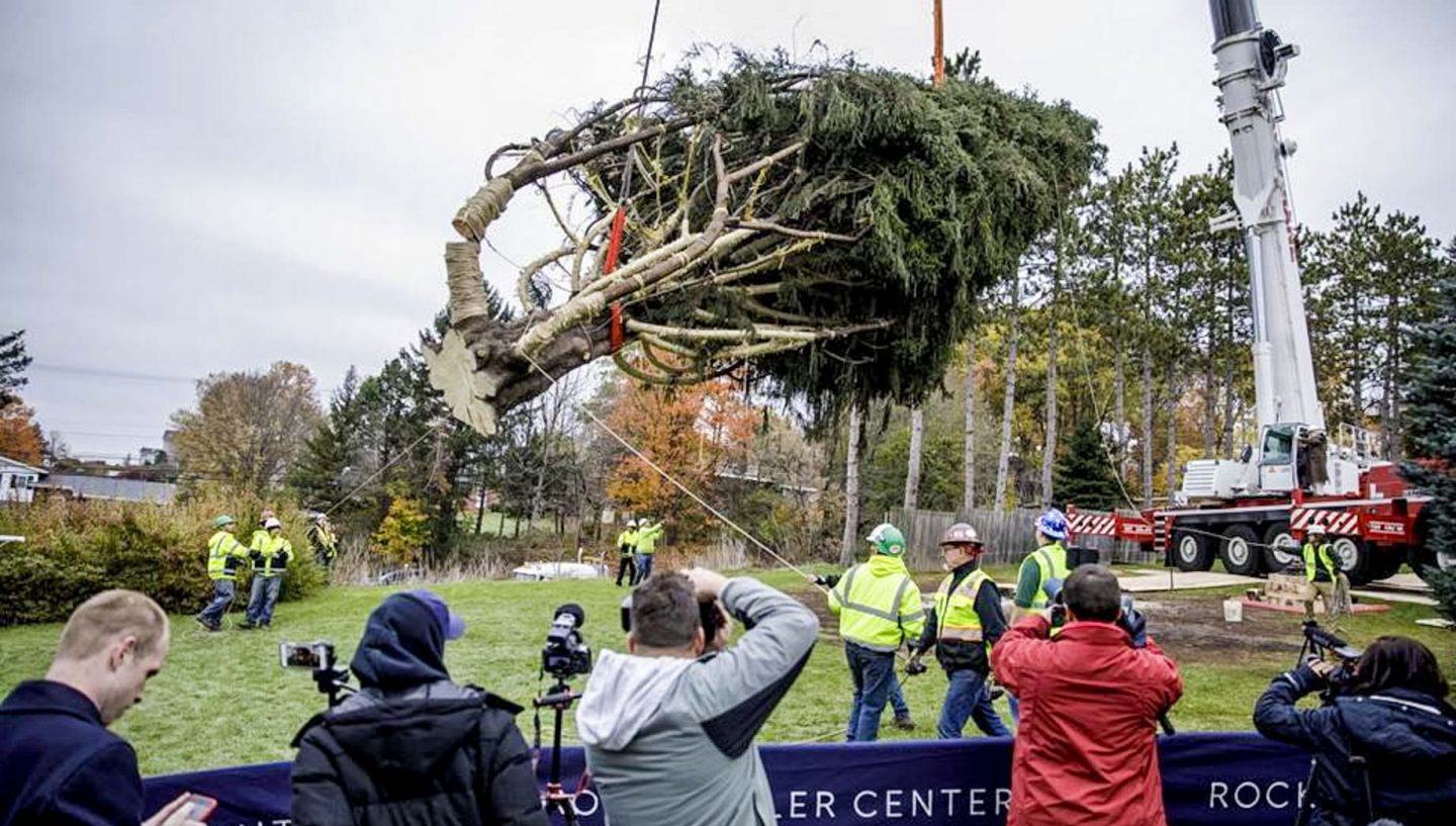 Crane lifting Christmas Tree in Rockefeller Center, photographers
